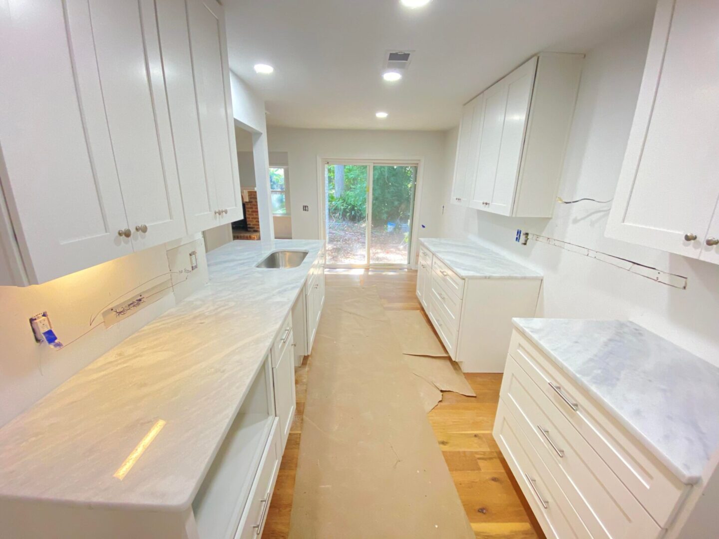 A modern kitchen under construction with white interiors