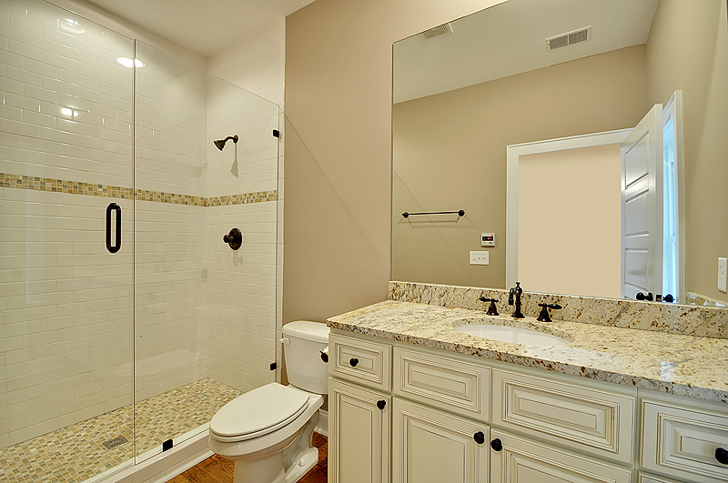 A view at the modern bathroom with glass doors and large mirrors
